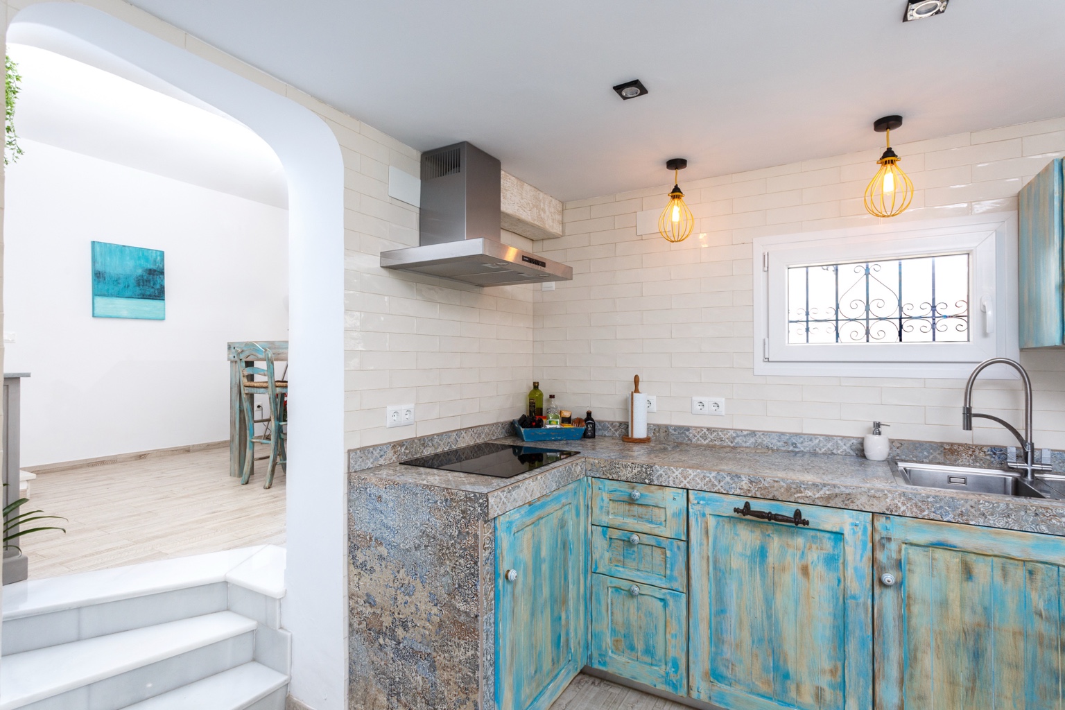 Kitchen with blue cabinetry and stone worktops