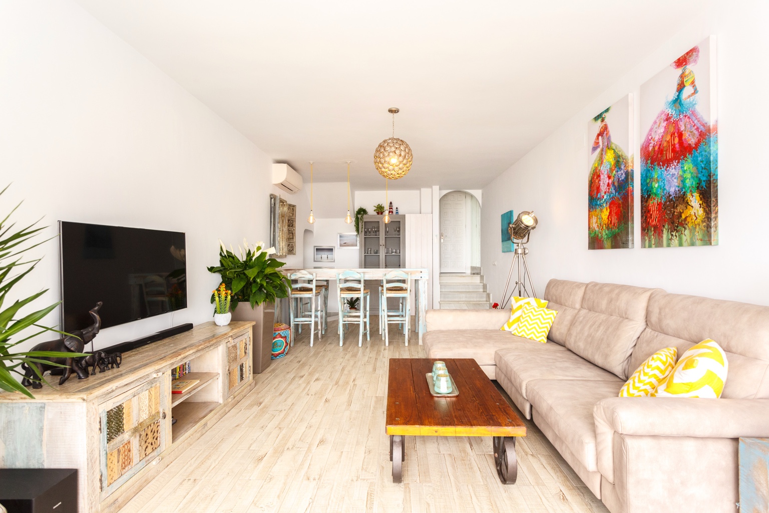 Bright living room with sofa, TV and dining area