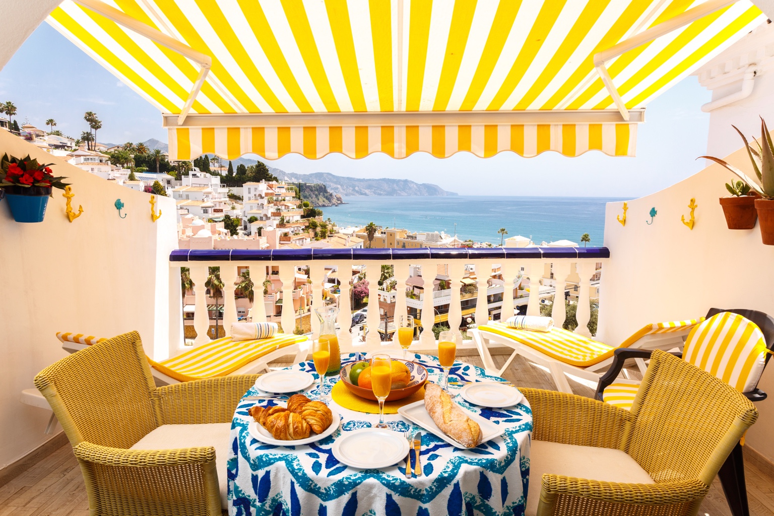 Sea-view terrace with breakfast table and loungers